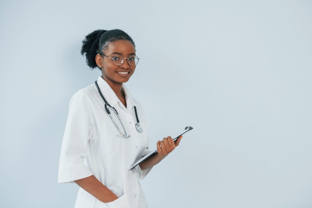 Young african american doctor is against white background